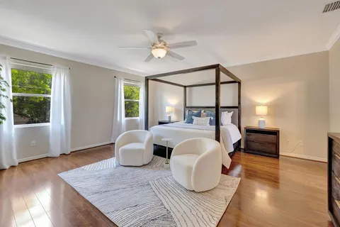 a bedroom with a large bed and wooden floor