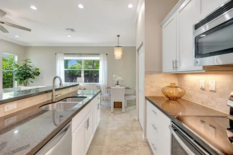 a kitchen with granite countertop a sink and a stove top oven