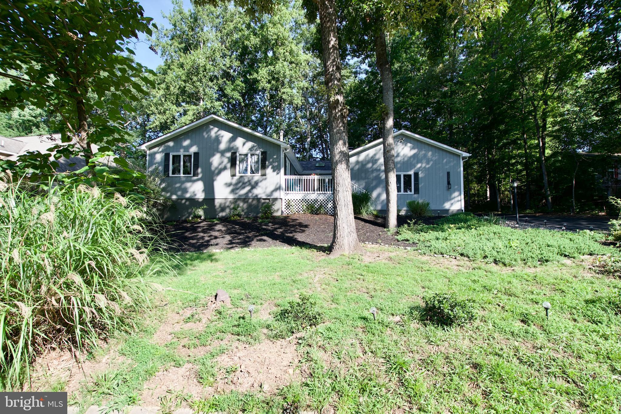 a front view of a house with a yard and trees