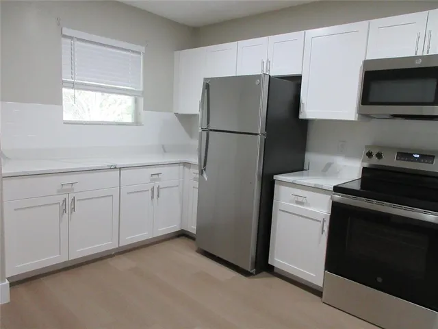a kitchen with a refrigerator sink and cabinets