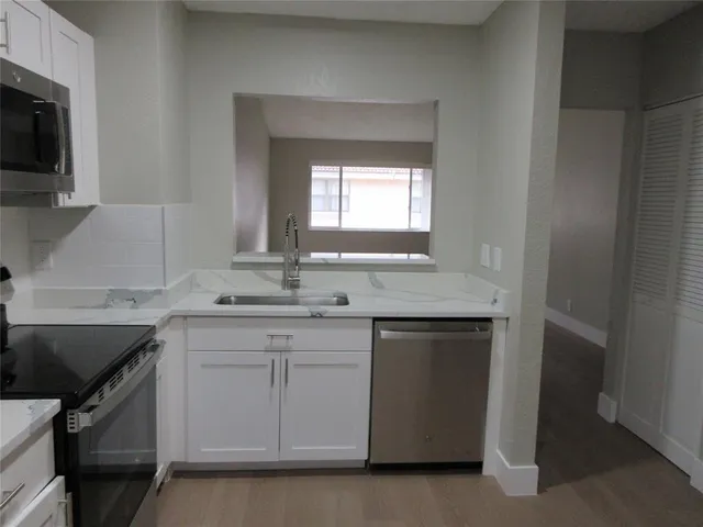 a kitchen with a sink stove and microwave