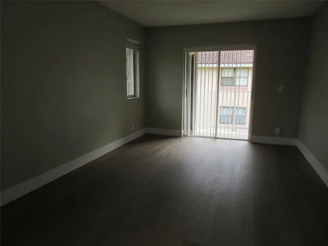 a view of a livingroom with wooden floor and a window