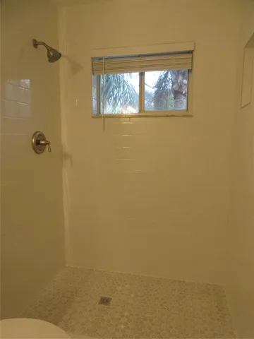 a bathroom with a window and a shower