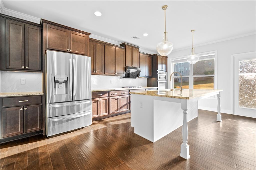 2770 Longacre Park Way Lawrenceville, GA 30044 - Photo 18 of 52 a kitchen with kitchen island a counter top space stainless steel appliances and wooden floor