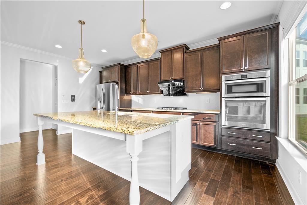 2770 Longacre Park Way Lawrenceville, GA 30044 - Photo 19 of 52 a kitchen with kitchen island granite countertop a sink appliances and cabinets