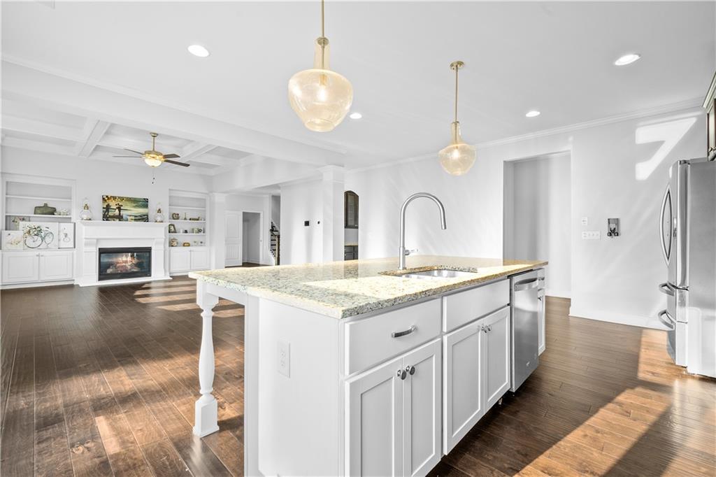 2770 Longacre Park Way Lawrenceville, GA 30044 - Photo 20 of 52 a large kitchen with stainless steel appliances kitchen island granite countertop a large stove a sink dishwasher and white cabinets with wooden floor