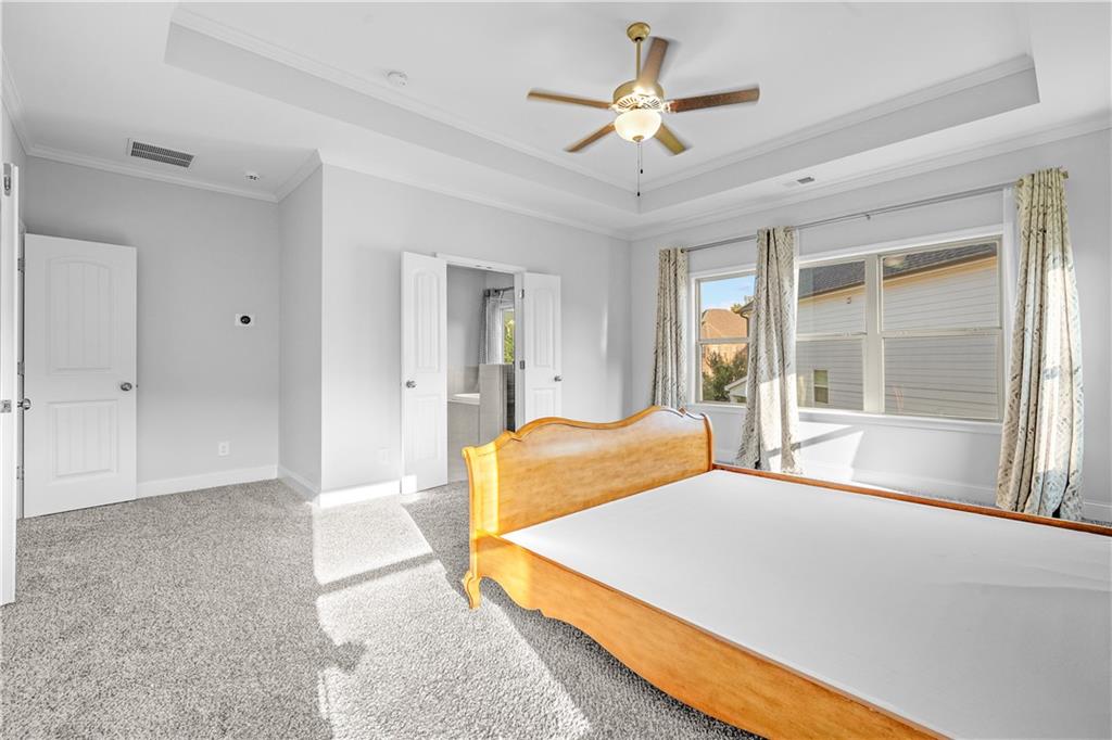 2770 Longacre Park Way Lawrenceville, GA 30044 - Photo 33 of 52 a bedroom with a large bed and a chandelier