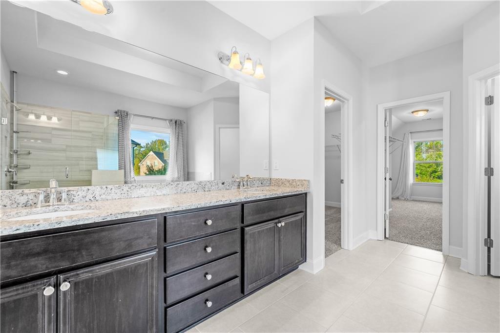2770 Longacre Park Way Lawrenceville, GA 30044 - Photo 36 of 52 a bathroom with a granite countertop sink and a mirror