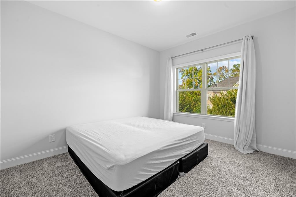 2770 Longacre Park Way Lawrenceville, GA 30044 - Photo 42 of 52 a bed sitting in a spacious bedroom next to a window