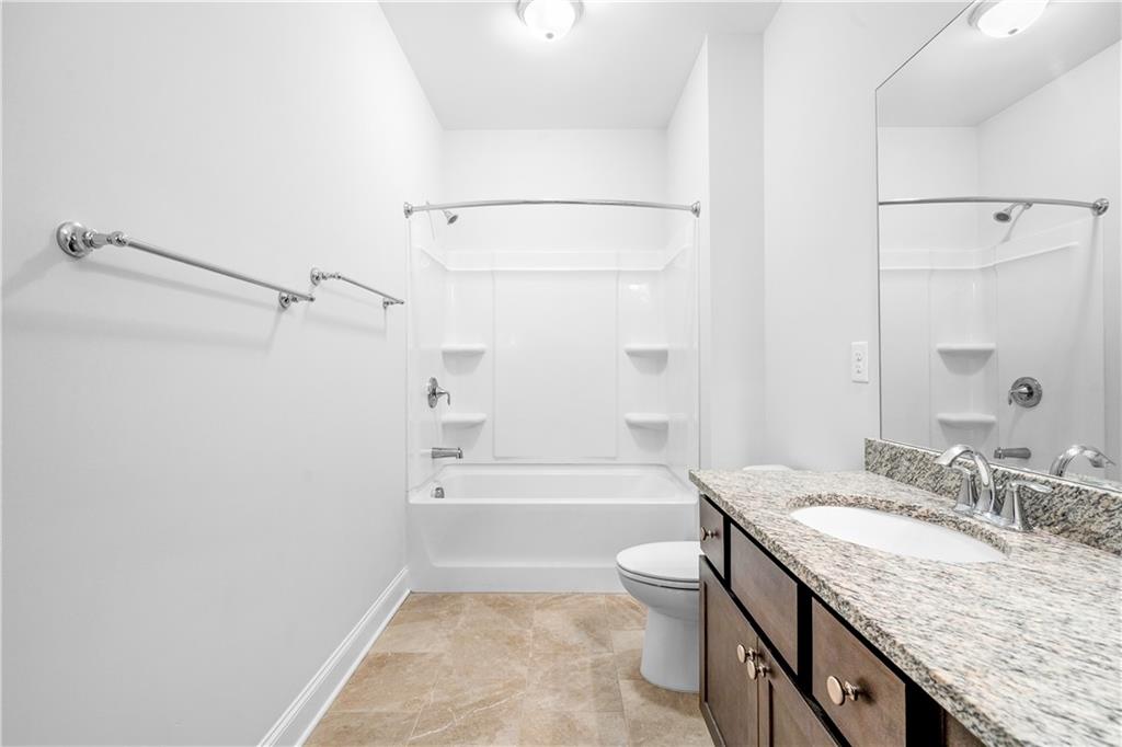 2770 Longacre Park Way Lawrenceville, GA 30044 - Photo 46 of 52 a bathroom with a granite countertop sink a toilet and bathtub