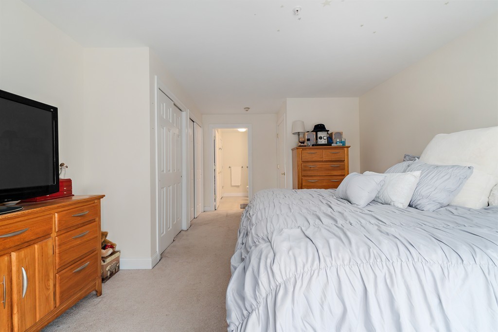 19 Broad Street, Unit 203 Merrimac, MA 01860 - Photo 15 of 20 a bedroom with a bed and a flat screen tv