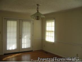 4525 Mobius Road Fayetteville, NC 28312 - Photo 2 of 4 an empty room with wooden floor and windows