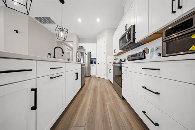 a living room with furniture and a dining table with wooden floor