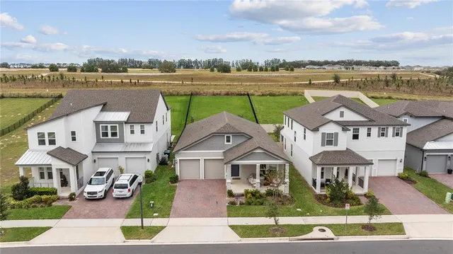 a front view of a house with a yard and potted plants