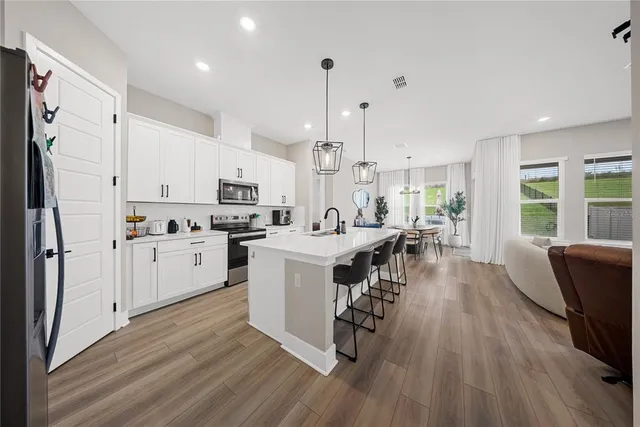 a kitchen with white cabinets and stainless steel appliances