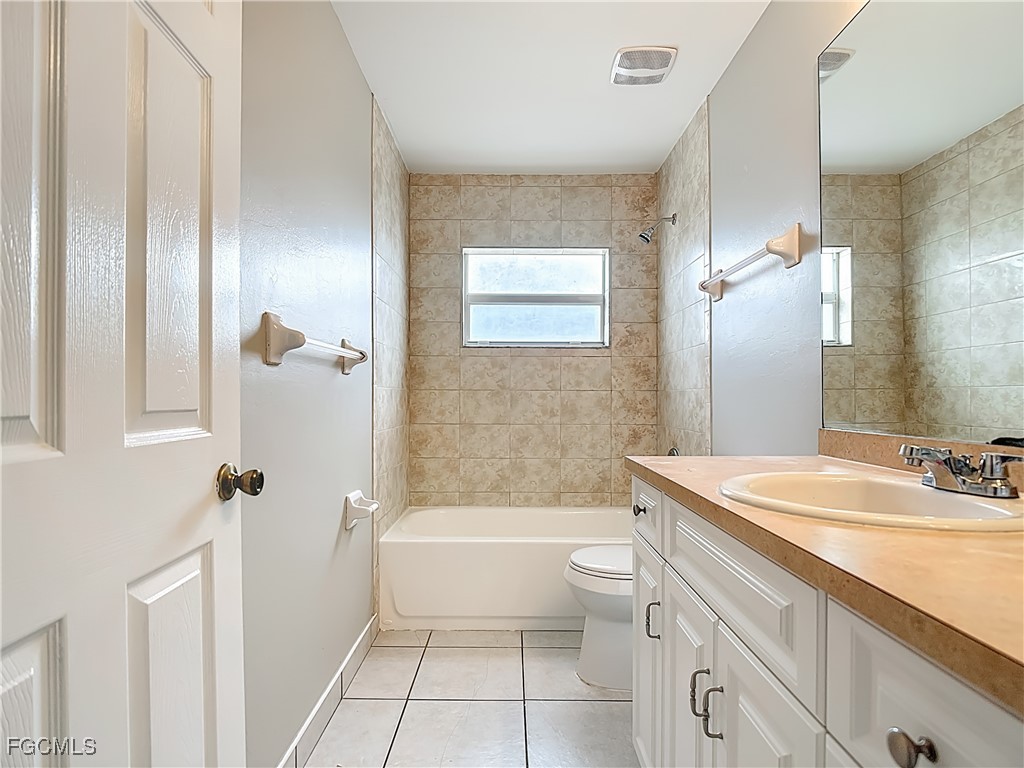 4034 29th Street Southwest Lehigh Acres, FL 33976 - Photo 14 of 22 a bathroom with a granite countertop sink toilet and shower