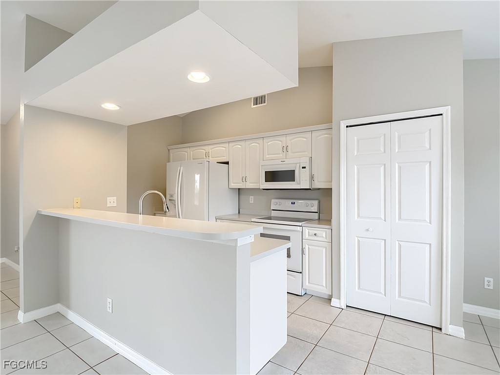 4034 29th Street Southwest Lehigh Acres, FL 33976 - Photo 7 of 22 a kitchen with stainless steel appliances a refrigerator sink and cabinets
