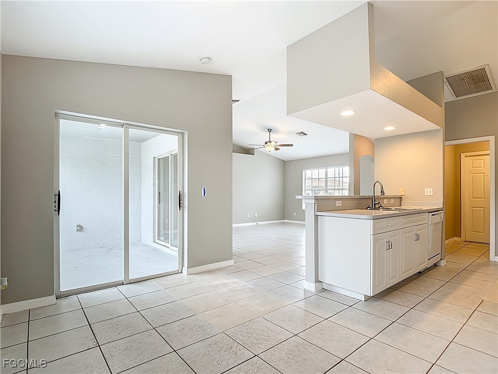 4034 29th Street Southwest Lehigh Acres, FL 33976 - Photo 9 of 22 a view of a kitchen with kitchen island granite countertop a refrigerator and a sink