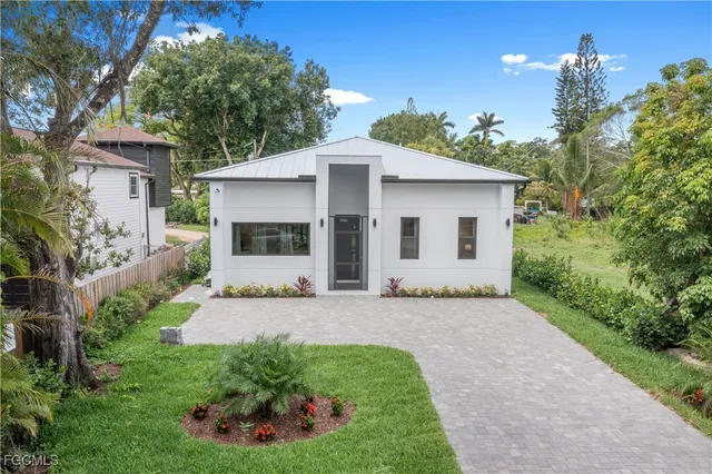 a front view of a house with a garden and yard