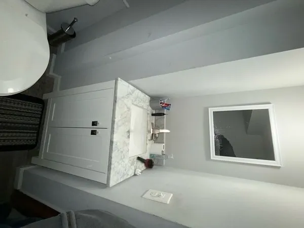 a bathroom with a granite countertop toilet and a sink
