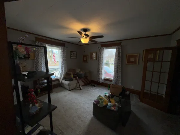 a living room with furniture a lamp and a large window