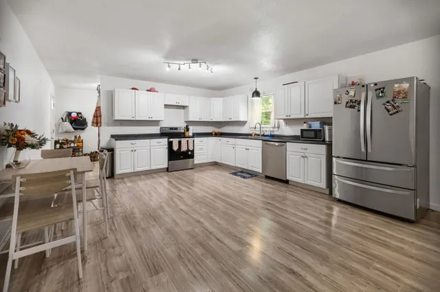 a kitchen with stainless steel appliances kitchen island granite countertop a refrigerator stove and sink