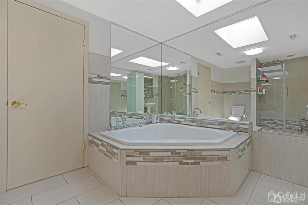 55 Gate House Lane Edison, NJ 08820 - Photo 24 of 28 a spacious bathroom with a bathtub and shower