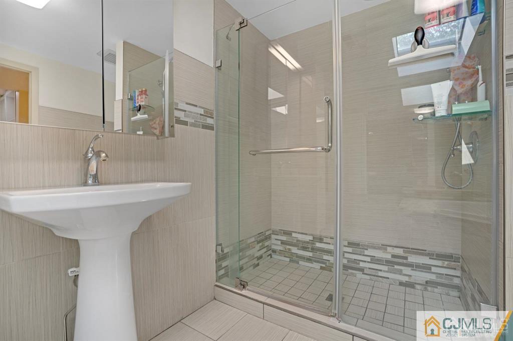 55 Gate House Lane Edison, NJ 08820 - Photo 25 of 28 a bathroom with a sink and a mirror