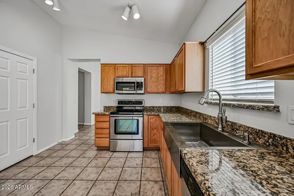 a kitchen with stainless steel appliances granite countertop a sink and a stove