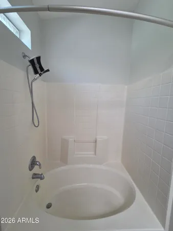 a white bath tub sitting next to a shower