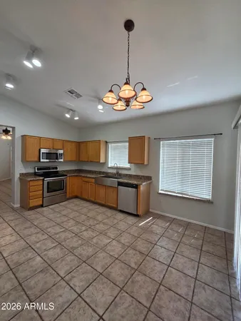 a kitchen with stainless steel appliances granite countertop a sink dishwasher and a open refrigerator