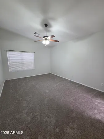 a view of an empty room with a chandelier fan