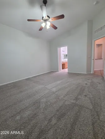 en empty room with windows and ceiling fan