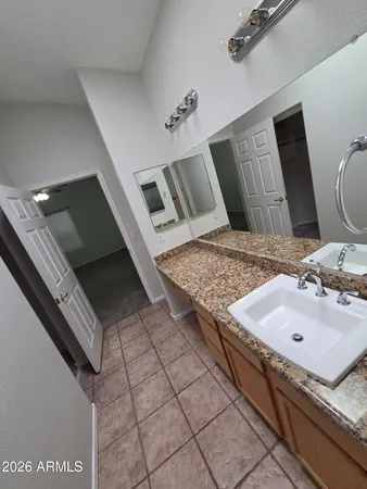 a en suite bathroom with a granite countertop sink