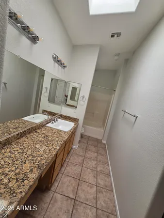 a bathroom with a granite countertop sink a toilet and mirror