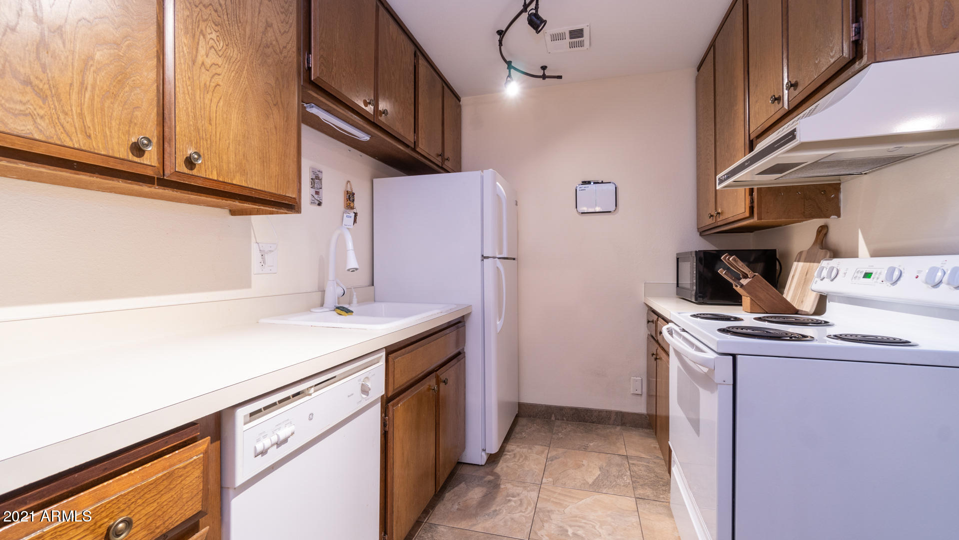 5525 East Thomas Road, Unit F14 Phoenix, AZ 85018 - Photo 6 of 20 a kitchen with stainless steel appliances granite countertop a sink stove and refrigerator