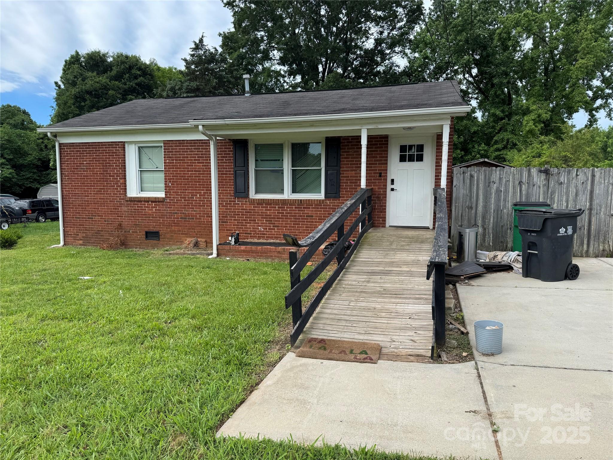 a view of a house with backyard and wooden fence