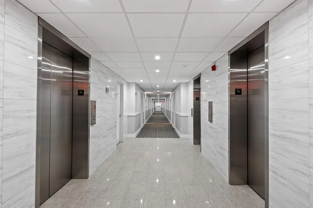 a view of a pool with tables and chairs under an umbrella