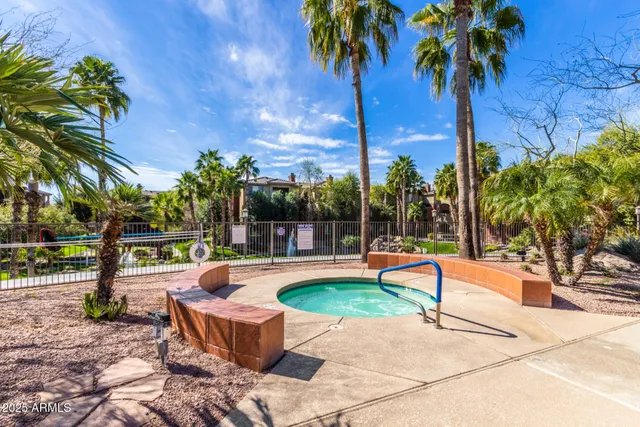 a view of a swimming pool with a lounge chair and palm trees