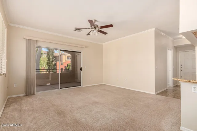 a view of a room with a empty space and a ceiling fan