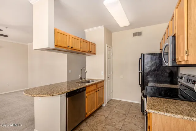 a kitchen with stainless steel appliances granite countertop a sink stove and refrigerator