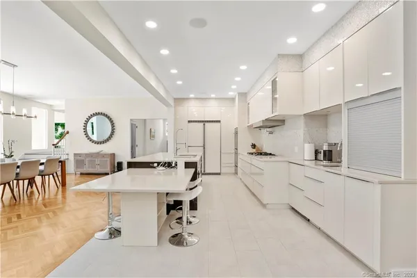 a large white kitchen with lots of counter space dining table and chairs