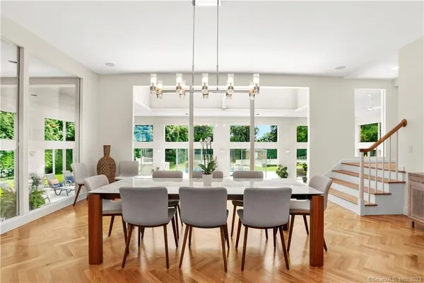 a dining room with furniture a chandelier and wooden floor
