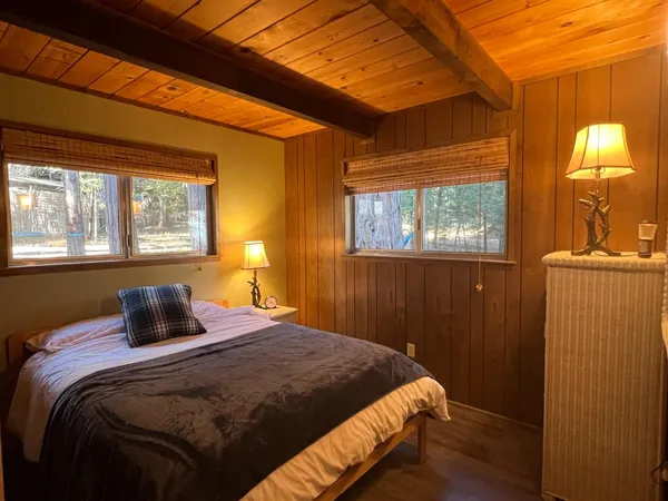 a bedroom with a bed and a mirror on dresser