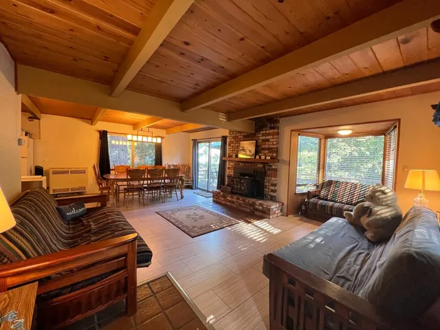 a living room with furniture kitchen view and large windows
