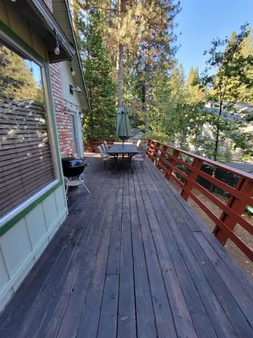 a balcony with wooden floor and outdoor seating