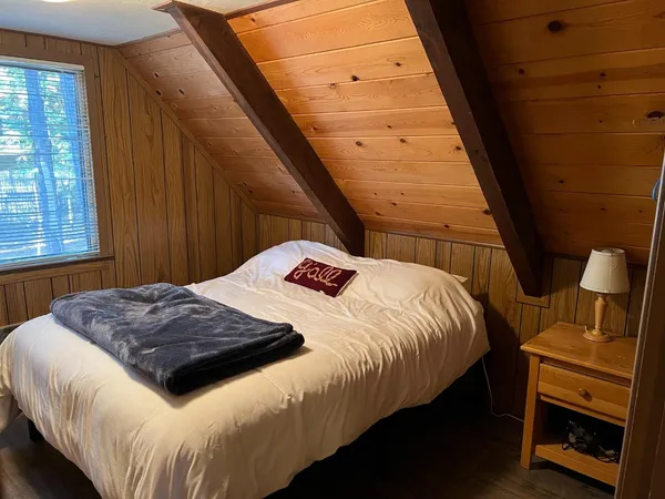 a bedroom with a bed and wooden floor