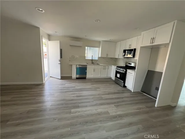 a view of a kitchen with furniture and wooden floor