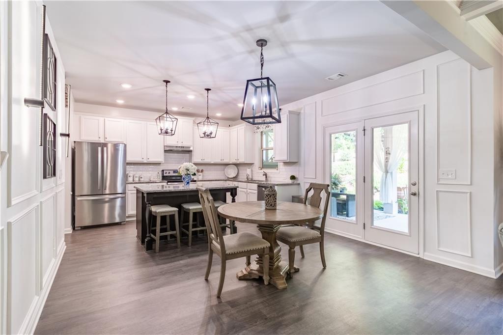 3041 Vista Ridge Braselton, GA 30517 - Photo 14 of 56 a dining room with wooden floor a chandelier a wooden table and chairs