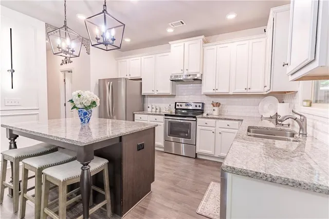 a kitchen with granite countertop white cabinets and white appliances